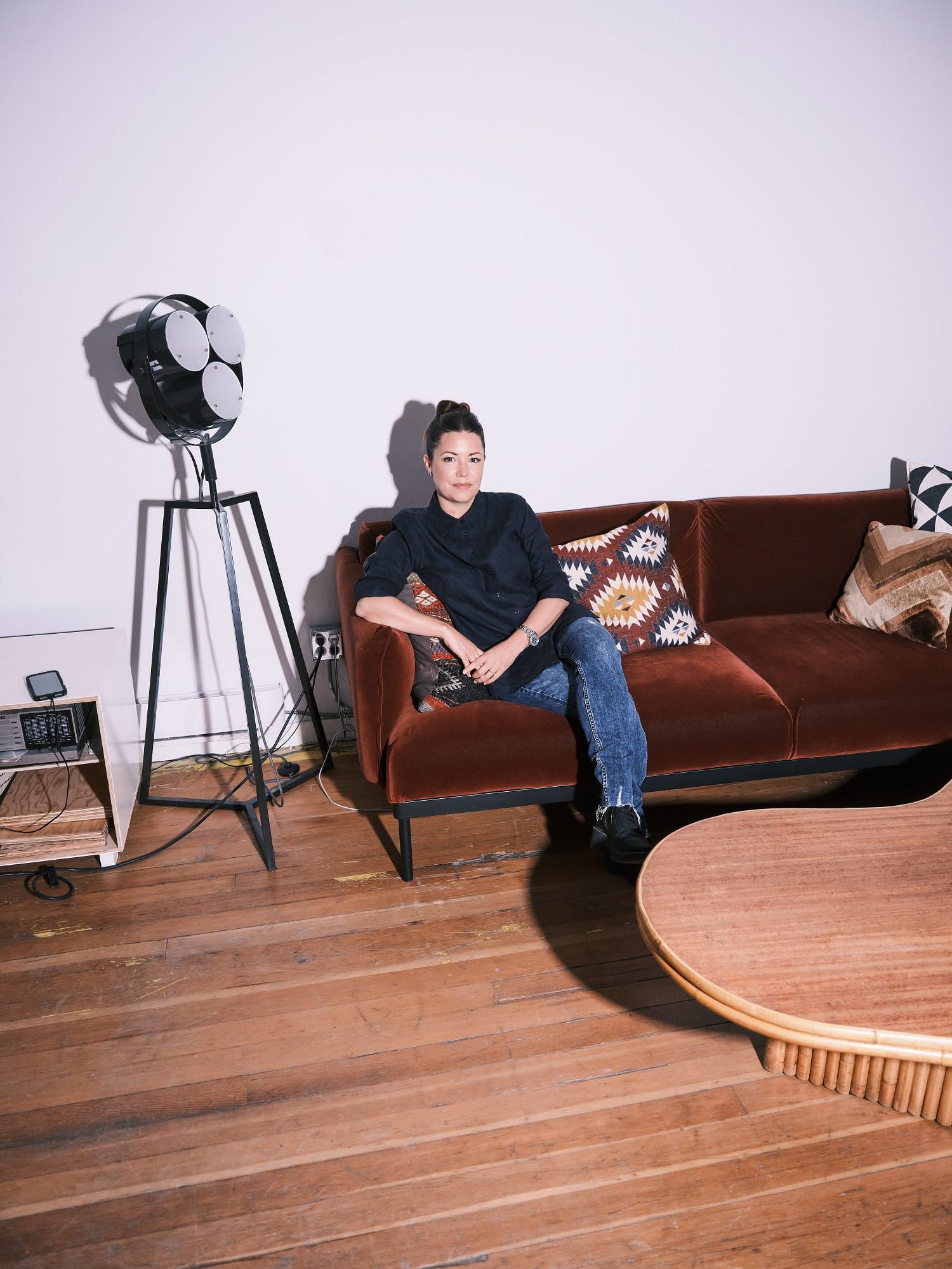 Katherine Gordon seated in the studio, beside a vintage tripod studio light