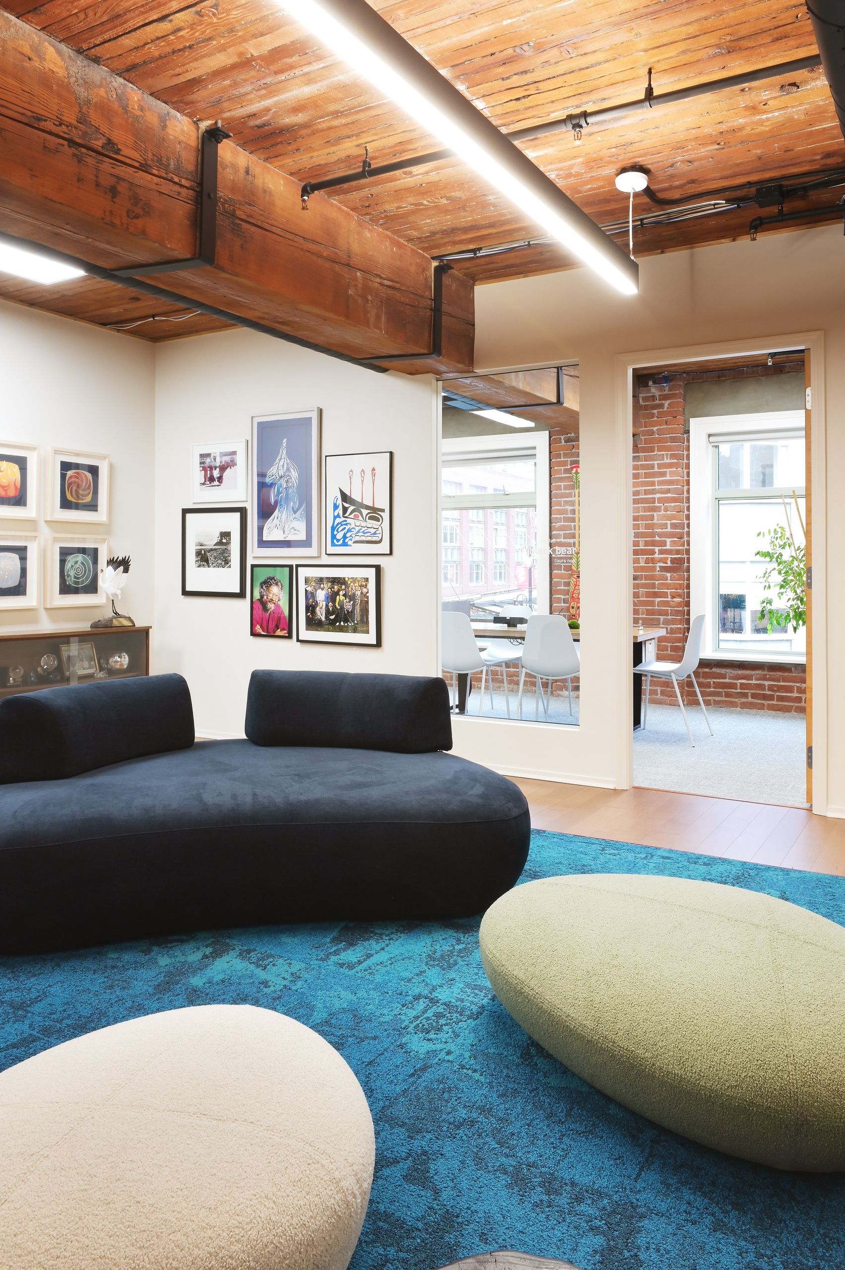 Lounge looking through to a glazed meeting room and the brick-walled office beyond