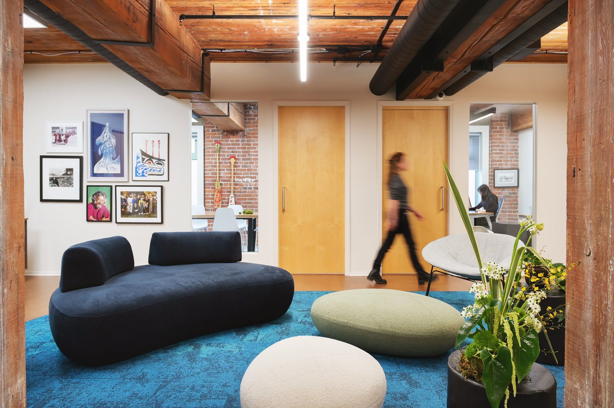 A staff member crossing the lounge between the meeting rooms and the open workspace