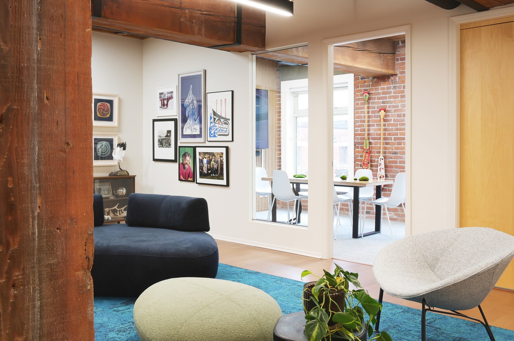 Lounge with a boucle shell chair and navy sofa, looking through to the meeting room