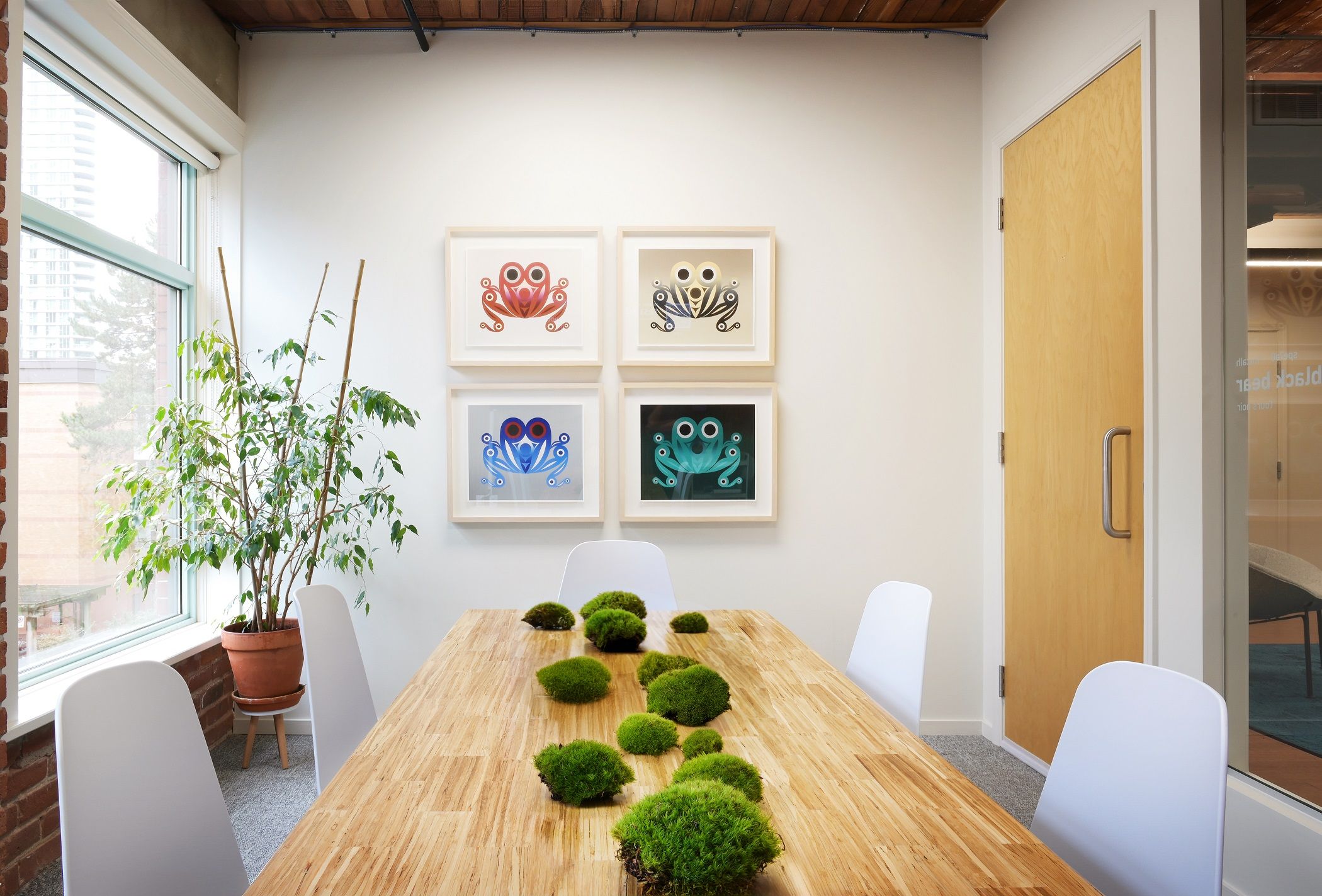 Meeting room with four framed frog prints and a moss runner along the table