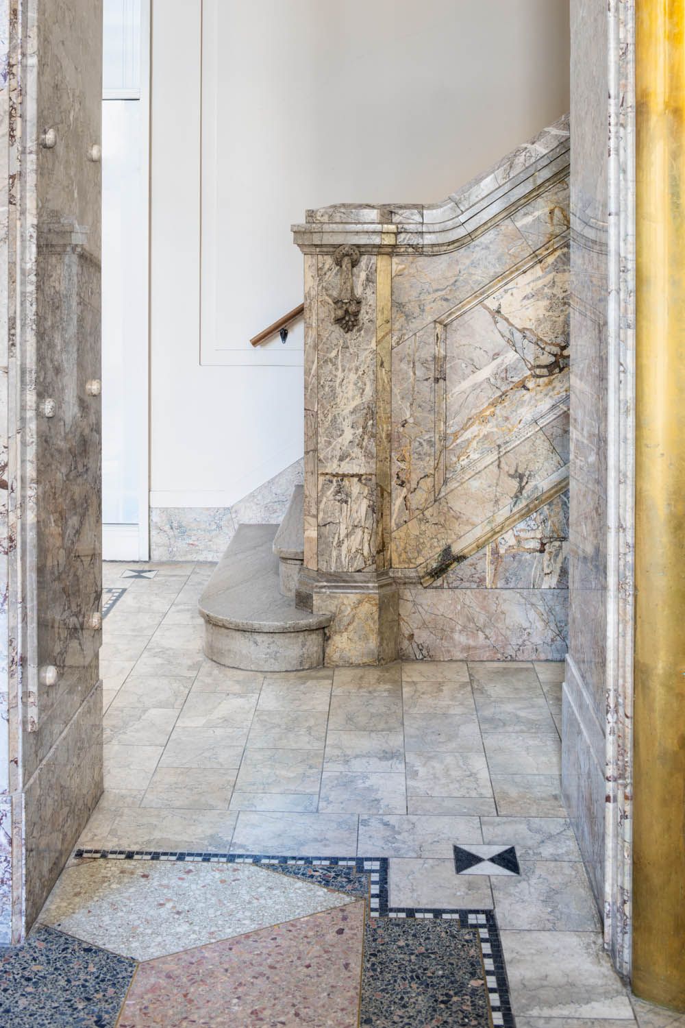 Carved marble newel and balustrade at the foot of the heritage stair