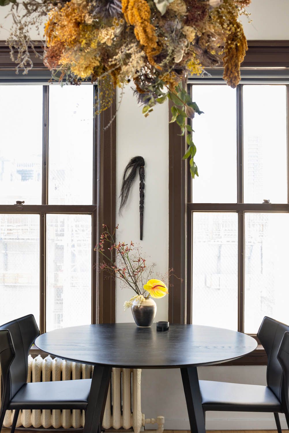 Round black table and leather chairs between the heritage windows