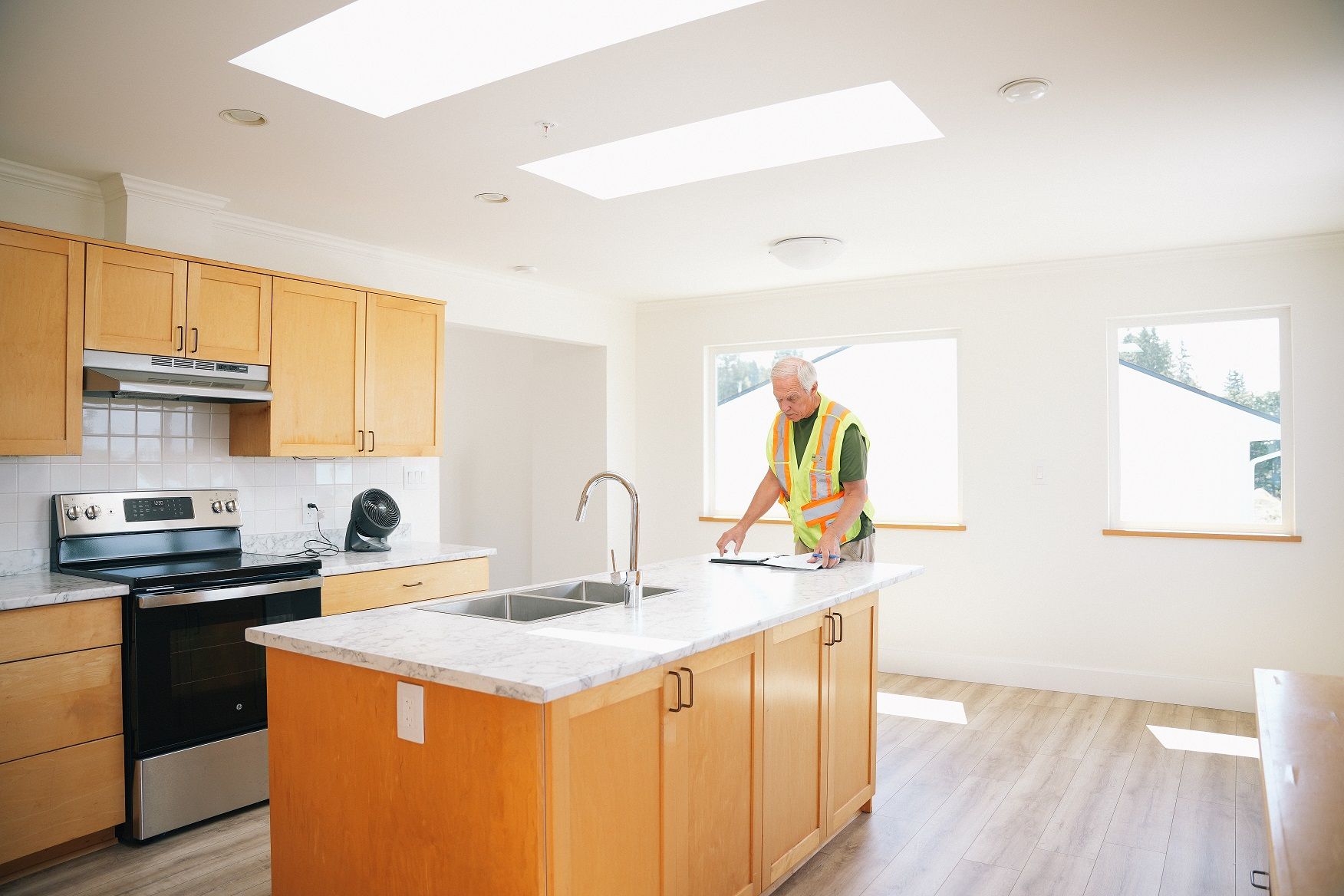 Site supervisor reviewing drawings at the kitchen island of a completed rental home