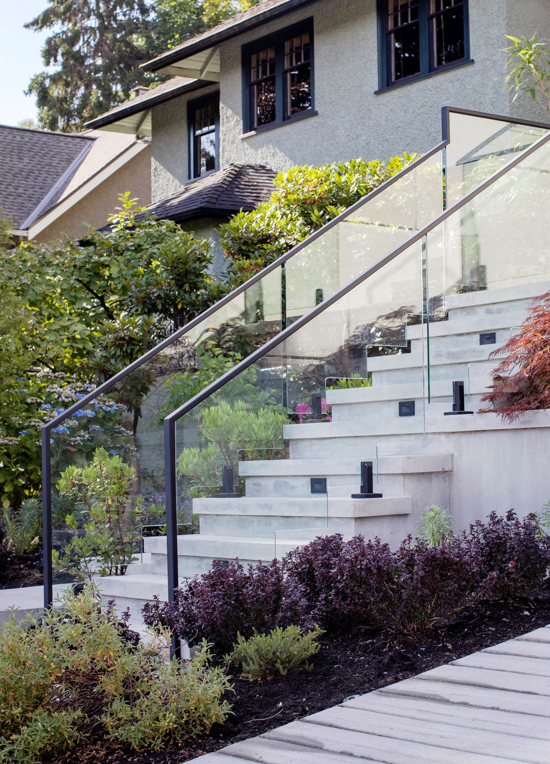The entry stair climbing between planting beds, with a neighbouring house behind