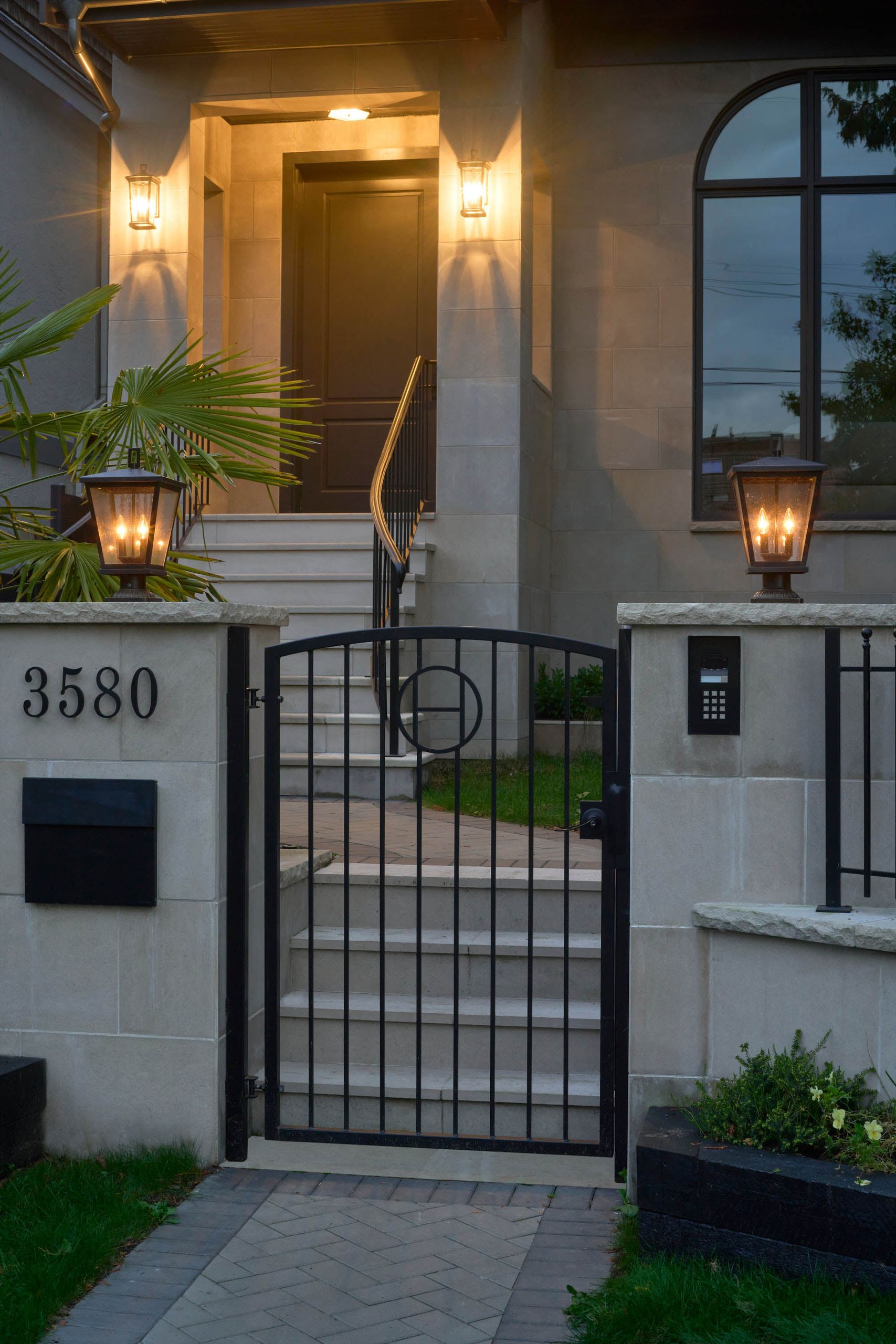The lit entry and gate after dark, lanterns glowing against the limestone