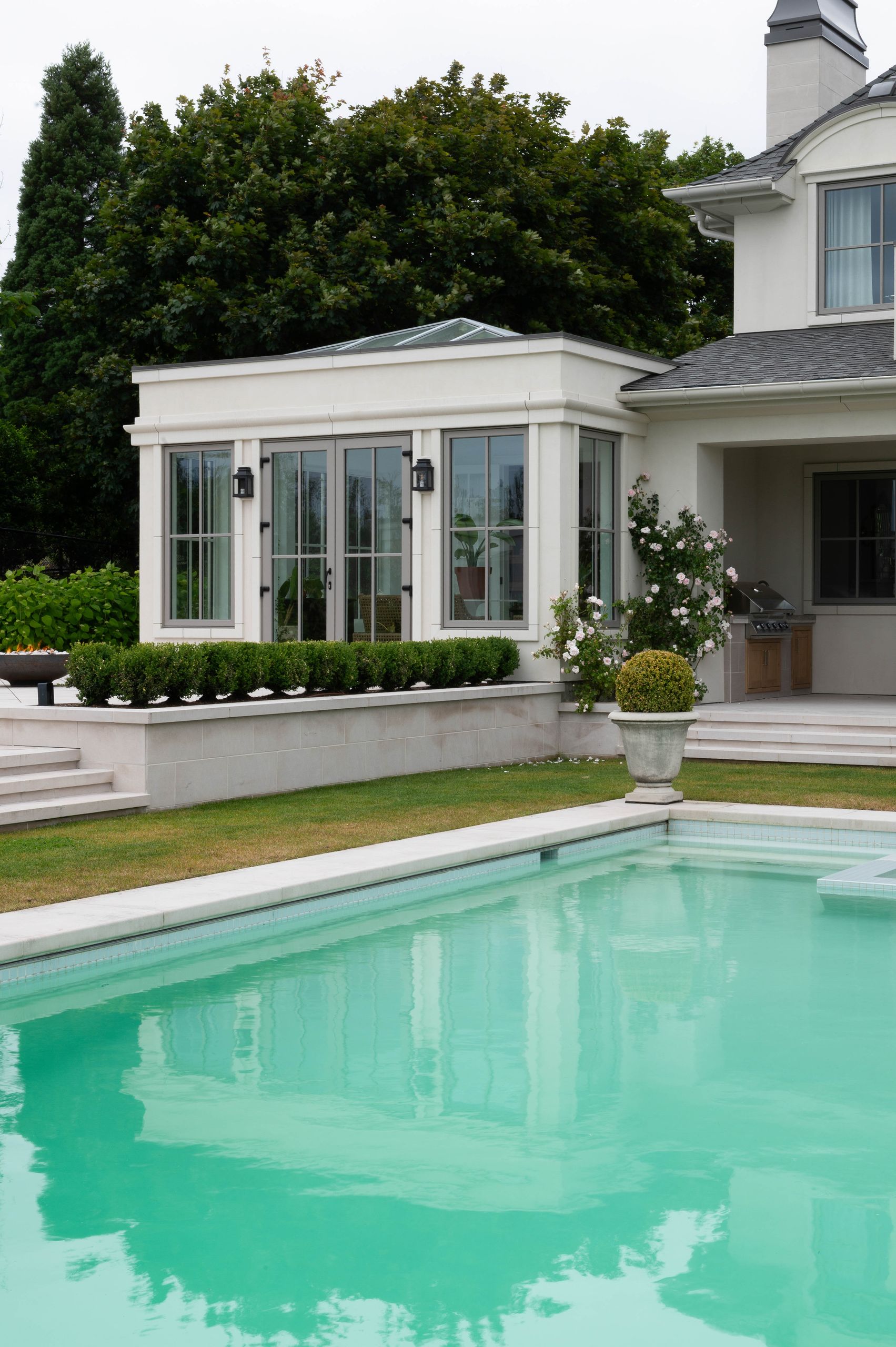 Garden pavilion with a glazed roof lantern beside the pool