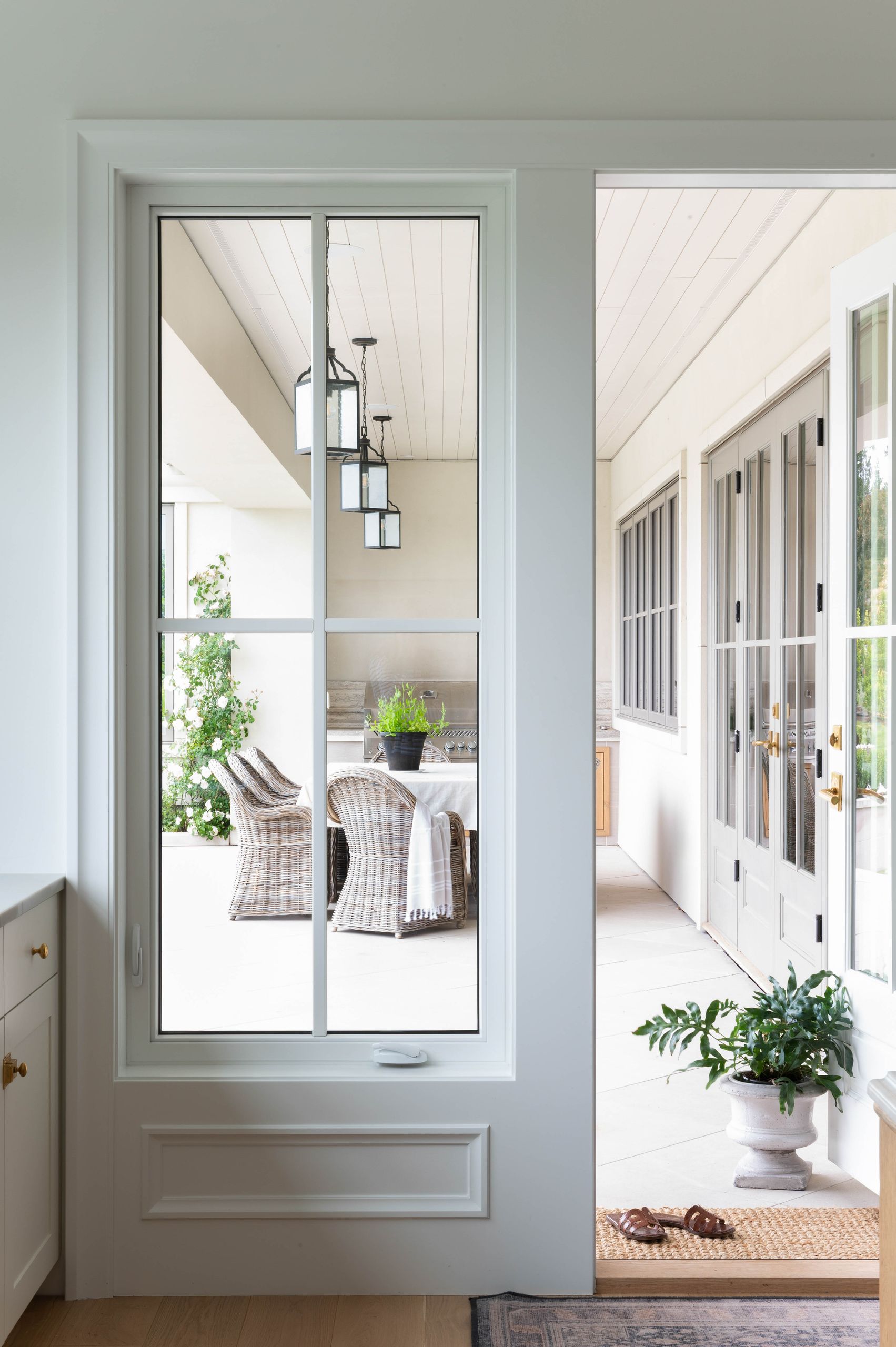 Looking out through the steel-framed window to the loggia and its wicker chairs