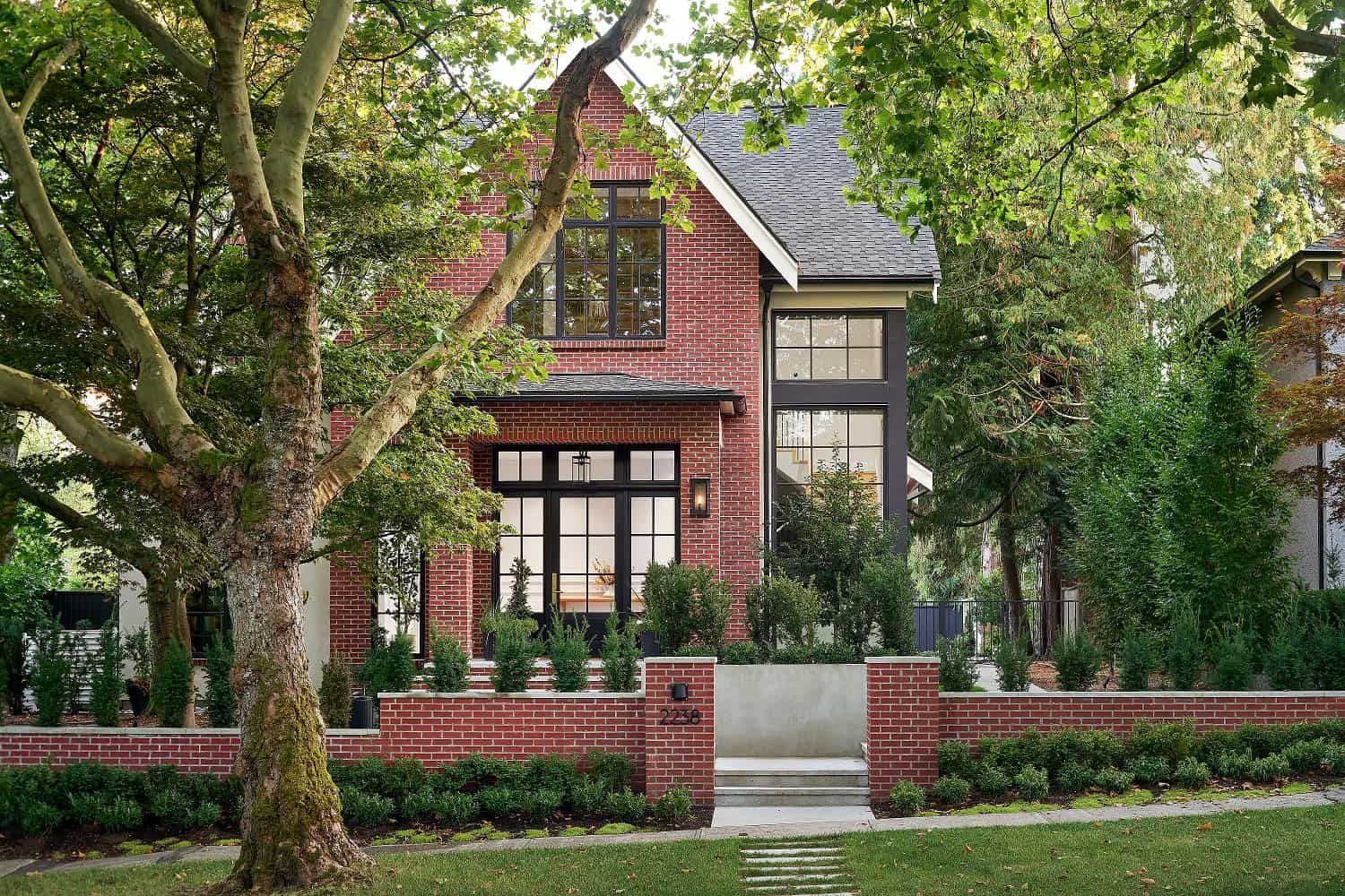 The residence framed by a mature plane tree, with stepping stones crossing the lawn
