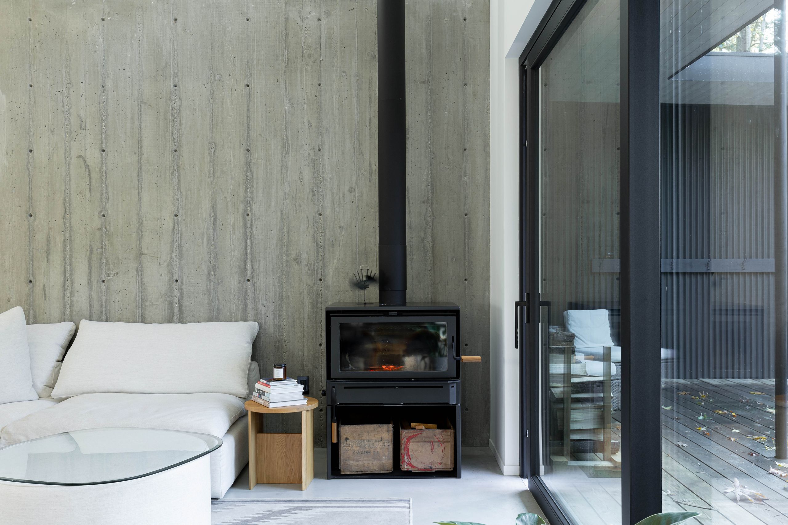 Living room with a wood stove set against the board-formed concrete wall