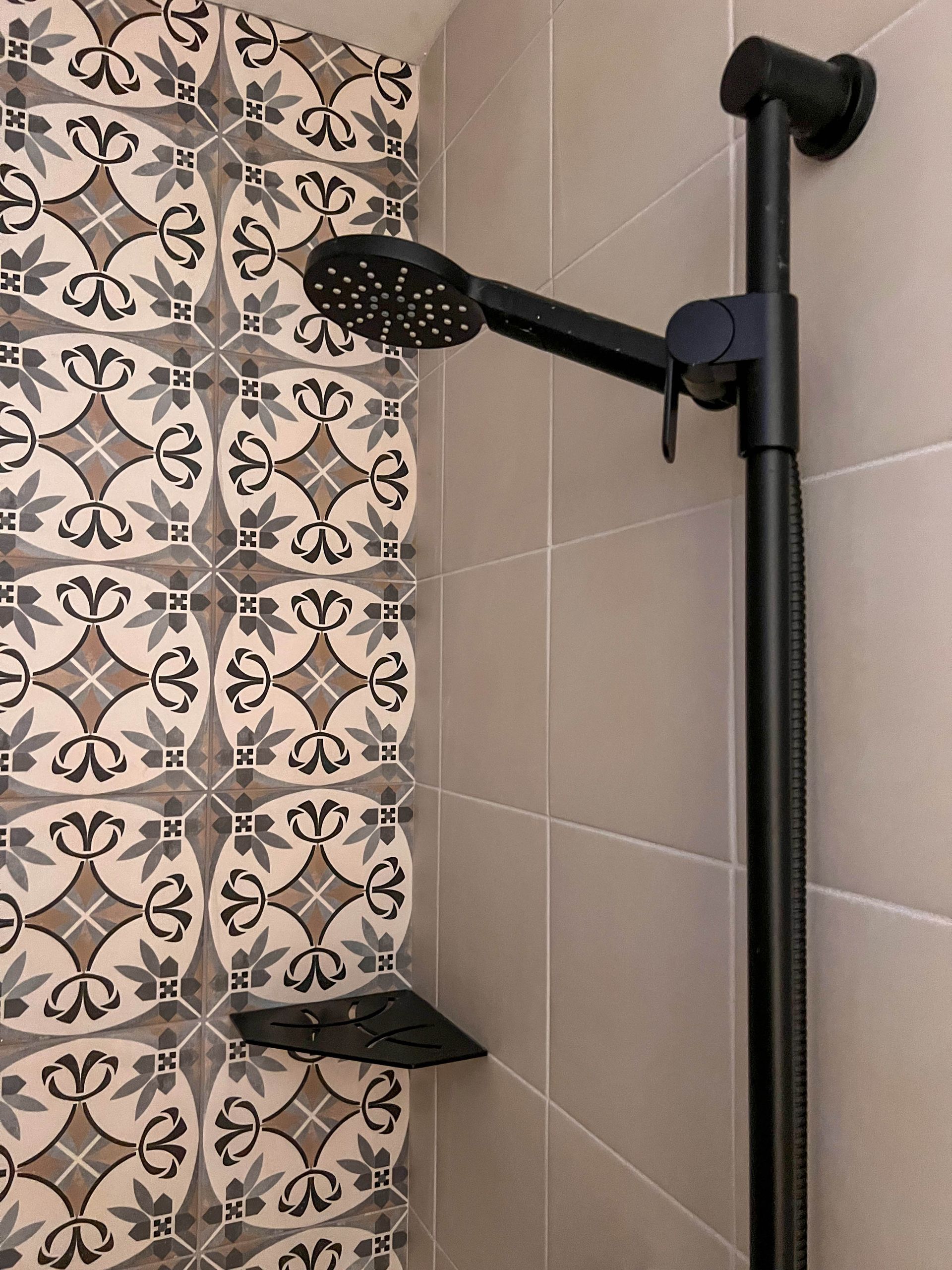 Shower with patterned encaustic feature tile and matte black fittings