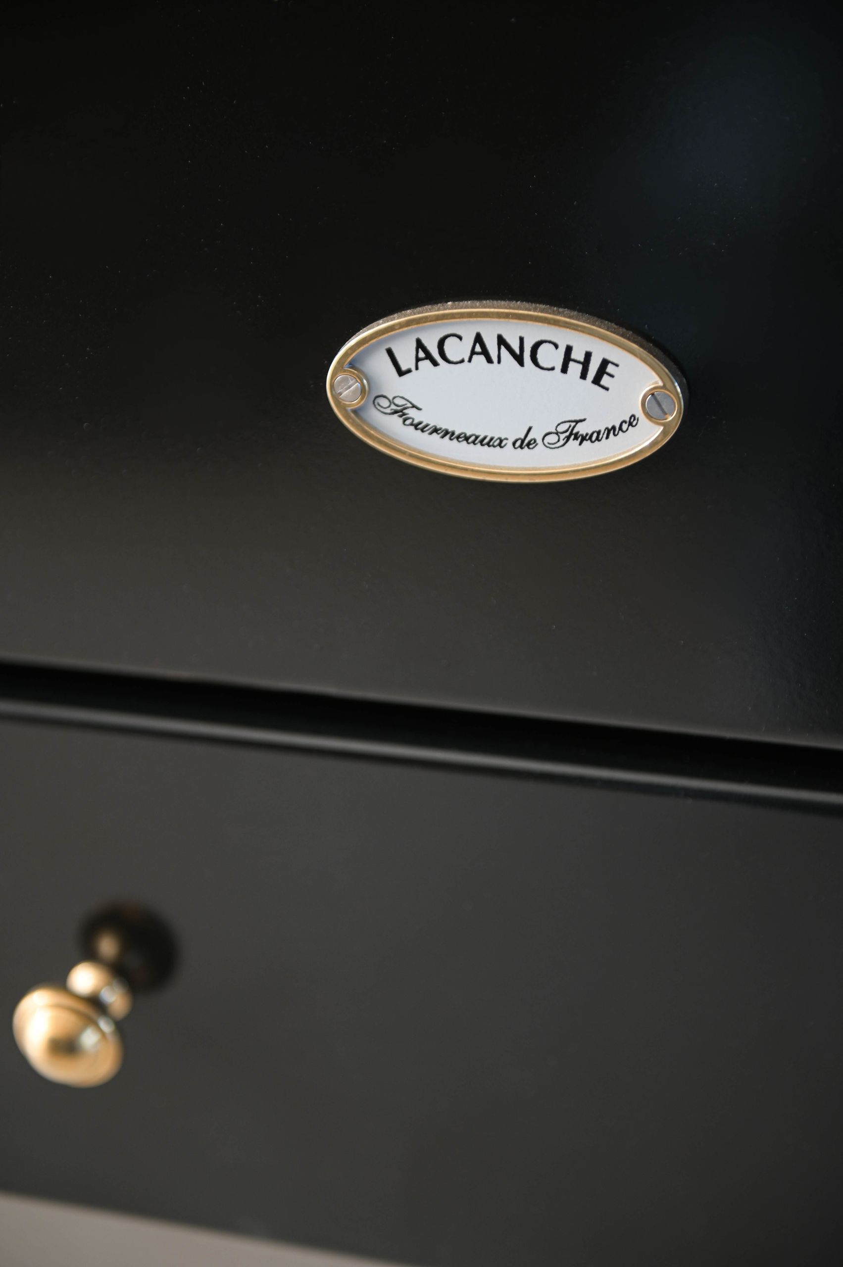 Enamel and brass maker's badge on the black range