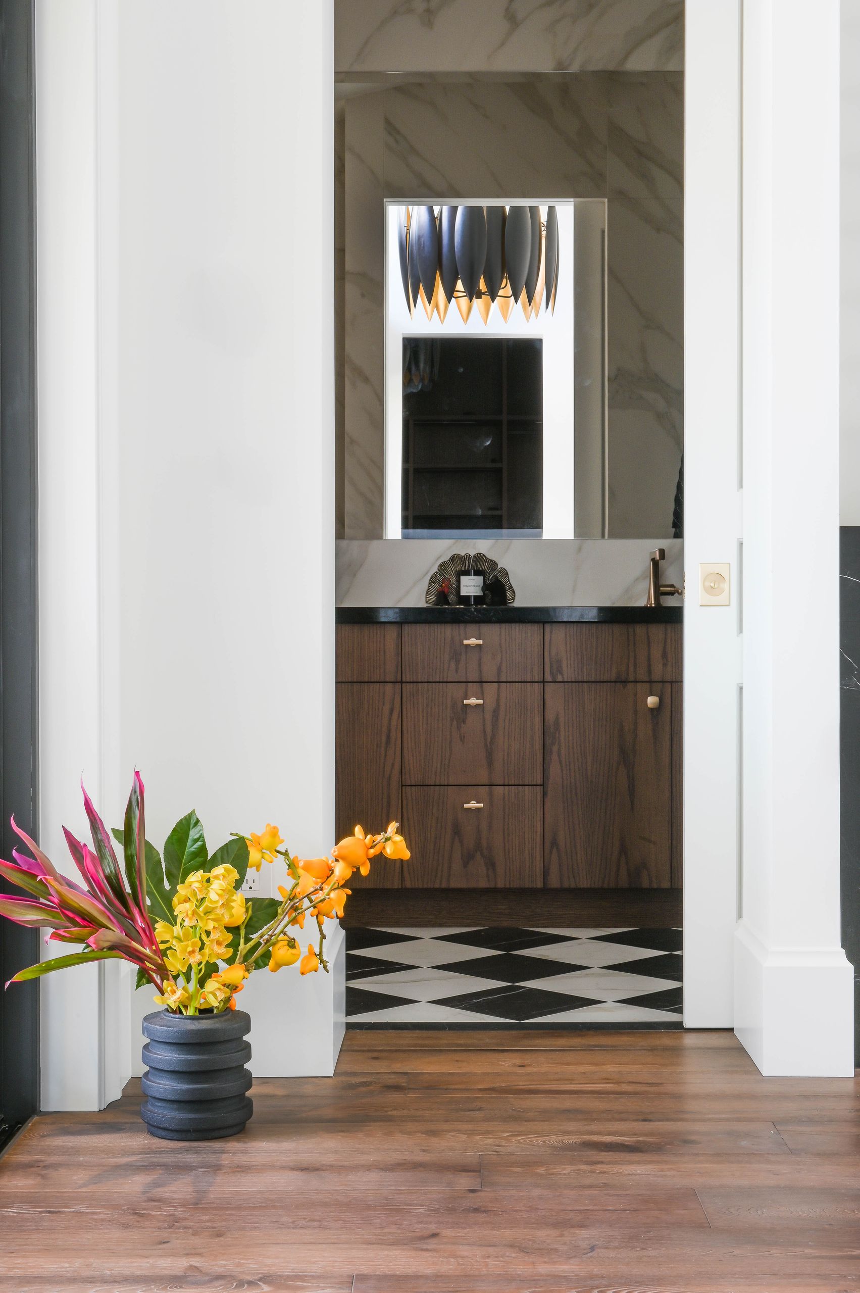 View through the doorway to the powder room and its black and white diamond marble floor
