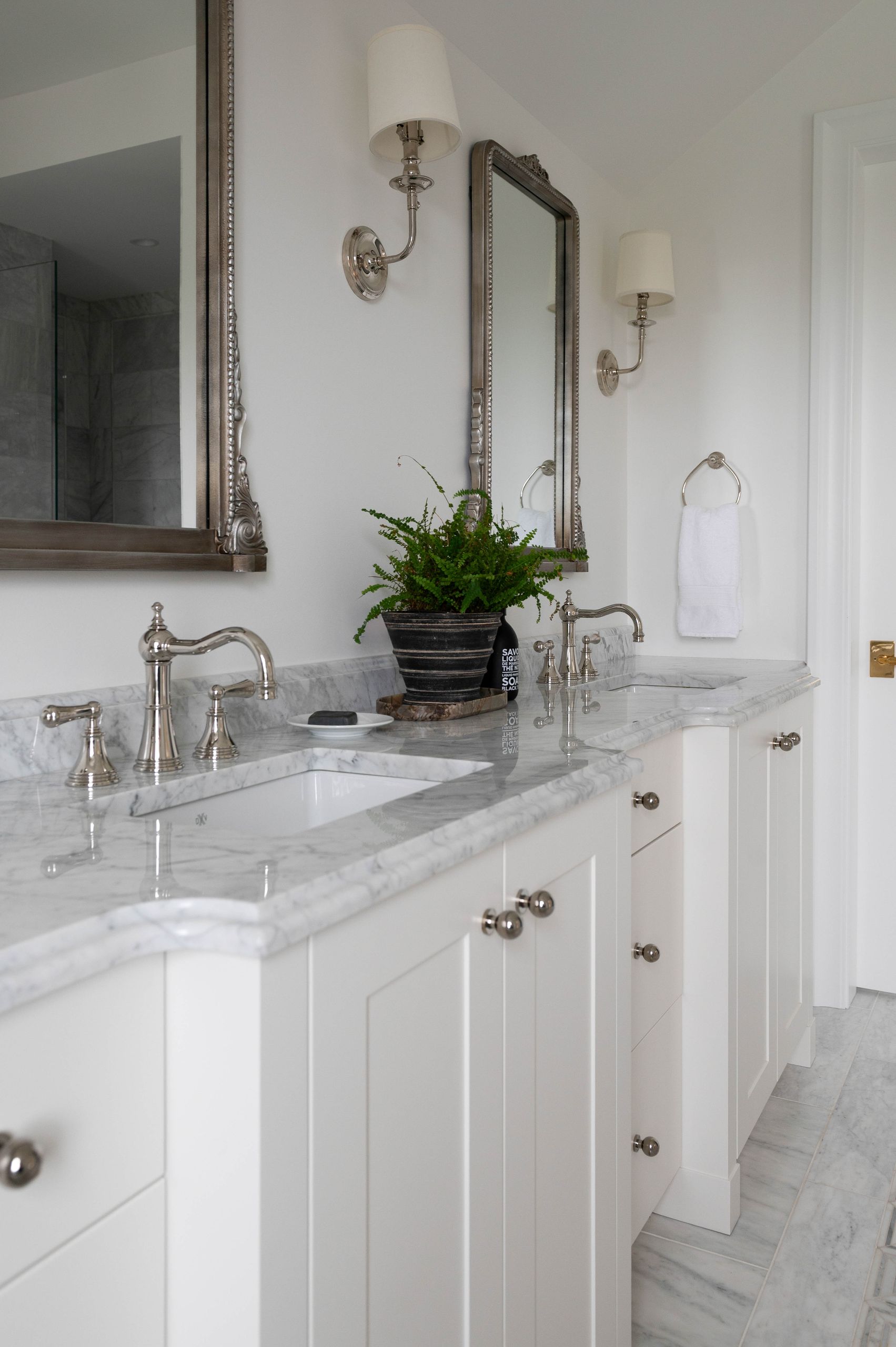 Double vanity with marble counters, silver-leaf mirrors and polished nickel fittings