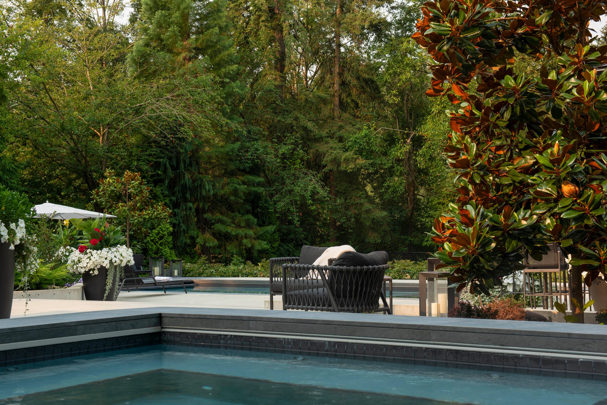 Looking across the spa to the loungers and umbrella at the far end of the pool