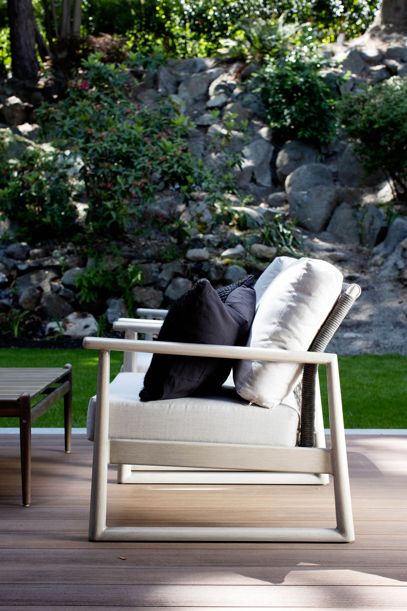 Pale wood lounge chair against the river-rock retaining wall