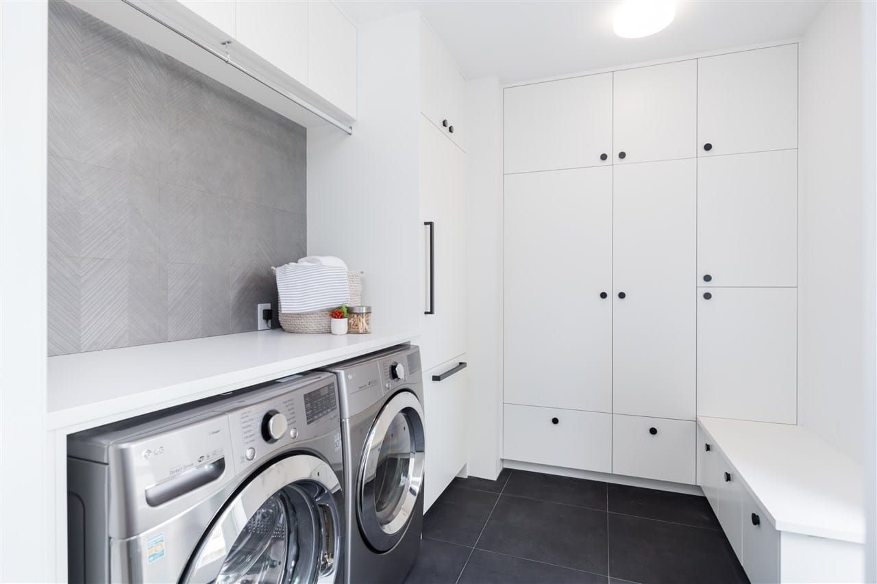 Laundry room with full-height cabinetry, a folding counter and a built-in bench